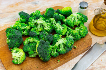 Wall Mural - Bunch of fresh green broccoli over wooden background. Healthy vegetarian food