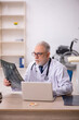 © Elnur - Old male doctor radiologist working in the clinic