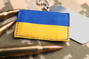 Wall Mural - Ukrainian army patch, bullets and ID tags on military camouflage, closeup