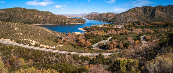 Wall Mural - Tranquil autumn forest lake landscape with curving paved road at Silverwood Lake along Rim of the World Scenic Drive in San Bernardino National Forest, California 