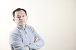 © DRN Studio - Middle-aged Japanese man in gray turtleneck wool sweater under white background. Concept image of Warm Biz, stability in daily life, and sustainable living.