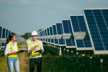 Asian Young Inspector Engineer man and female walking checking operation in solar farm