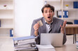 © Elnur - Young male employee unhappy with excessive work in the office