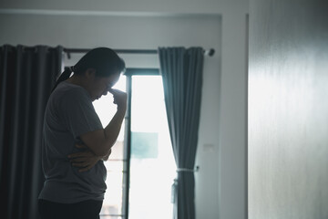 Wall Mural - Schizophrenia with lonely and sad in mental health depression concept. Depressed woman standing against with dark room feeling miserable at home . Women are depressed, fearful and unhappy.