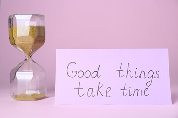 Wall Mural - Card with phrase Good Things Take Time and sand clock on pink background. Motivational quote