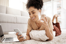 Relax, Phone And Black Woman On Social Media For News Reading Or Funny Online Content On Living Room Floor. Smile, Meme Or Happy Girl Enjoys A Glass Of Water For Wellness Or Healthy Hydration At Home