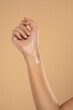 © vladimirfloyd - Close up cropped woman hand perfect skin hand cream isolated on beige studio  background. Skin care healthcare procedures concept