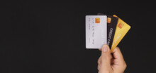 Hand Is Holding Three Credit Cards Isolated On Black Background.