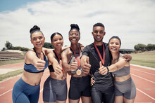 Team, thumbs up and sport winner with medal, runner and happy in portrait, success and win on race track. Young black man, diversity and fitness, athlete winning with exercise and collaboration.