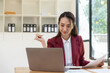 © Natee Meepian - Portrait of young asian business woman using laptop computer for financial paperwork analysis.