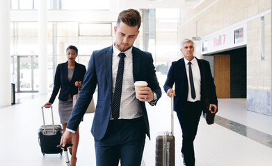 Travel, international meeting and business people walking in hotel, airport and reception area with suitcase. Teamwork, collaboration and group of managers travelling for global business meeting