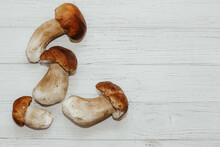 Boletus Edulis On A Table Made Of White Boards Preparation For Eating.