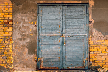 Wall Mural - Old closed door with a padlock, against the background of an old, peeling  wall