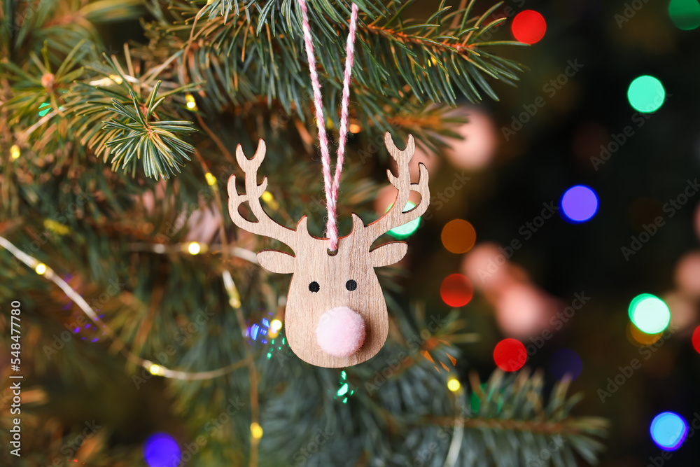 Christmas reindeer toy on fir tree, closeup