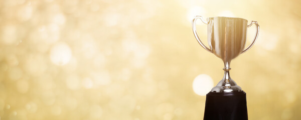 Wall Mural - golden trophy award with bokeh soft gold background. copy space for text. winner or 1st place gold t