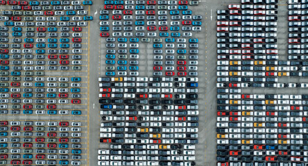 Wall Mural - Aerial view of new cars stock at factory parking lot. Above view cars parked in a row. Automotive industry. Logistics business. Import or export new cars at warehouse. Big parking lot at port terminal