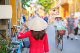 Fototapeta Kuchnia - happy woman wearing Ao Dai Vietnamese dress, asian traveler sightseeing at Hoi An ancient town in central Vietnam. landmark and popular for tourist attractions. Vietnam and Southeast travel concept
