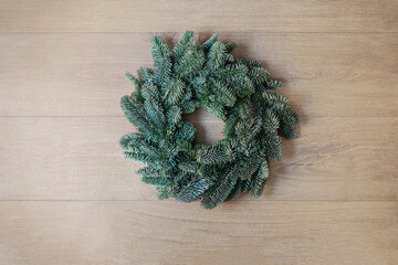 Wall Mural - Christmas fir tree on dark wooden background  top view, flat lay. Xmas wreath. Nature New Year concept..