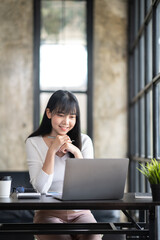 Asian Business woman using calculator and laptop for doing math finance on an office desk, tax, report, accounting, statistics, and analytical research concept