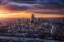 The Skyline Of The City Of London With The Modern Office Skyscrapers Reflecting The Warm Sunlight Of A Cloudy Winter Sunset, England