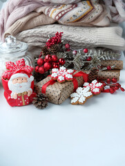 Wall Mural - Christmas holiday background. Santa Claus cup, gift box, Christmas cookies, sweaters close up. festive winter season. 