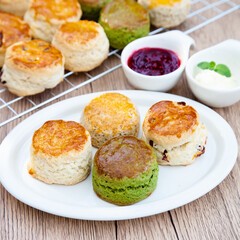 Wall Mural - Four flavours of homemade scone with raspberry jam and clotted cream (butter, cranberry, matcha and Earl Grey)