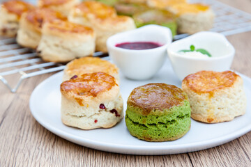 Wall Mural - Four flavours of homemade scone with raspberry jam and clotted cream (butter, cranberry, matcha and Earl Grey)