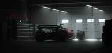 Back View Silhouette Of A Modern Generic Sports Racing Car Standing In A Dark Garage On A Pit Lane, Cinematic Lighting. Realistic 3d Rendering