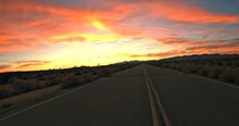 Stunning Golden Sunset While Driving Through The Mojave Desert With Joshua Trees In Silhouette