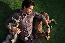 Man Lying On Lawn With Pets