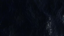 Aerial View Of The Dark Ocean. Ripples And Waves On Deep Water Surface.  Turbulent Sea Reflects The Bright Moonlight. Soft And Relaxing Movement. Night Top View. Liquid Background.