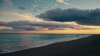 Wall Mural - Calm waves of ocean crashing on the beach with beautiful sunset sky