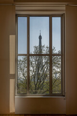 Wall Mural - Paris, France - 03 26 2022: View of the Eiffel Tower and a tree through a window