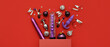 Box with different sex toys and Christmas decor on red background