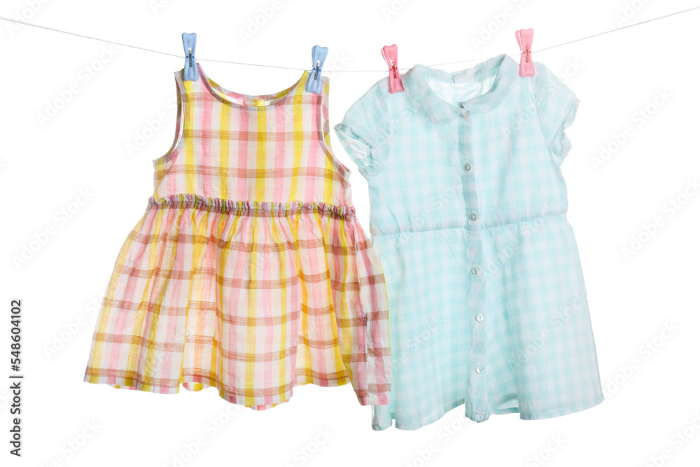 Baby clothes hanging on laundry line against white background
