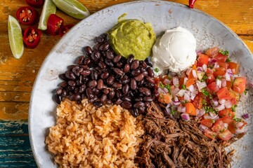 Sticker - Top-view of a barbacoa burrito bowl, meat rice black beans sour cream guacamole  chopped vegetables