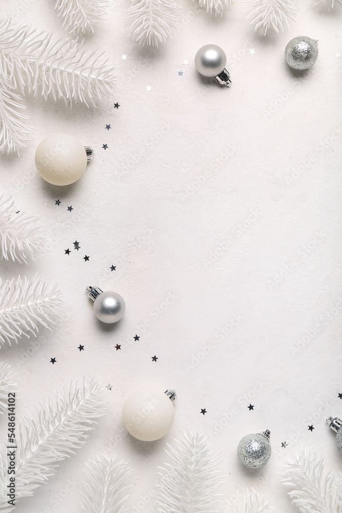 Composition with Christmas balls and white fir branches on light background