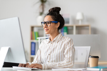 Sticker - Young female entrepreneur using computer and typing, working online at workplace in office, copy space