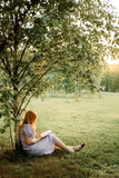 Fototapeta  - woman reading a book in the park