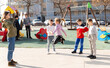 Happy kids playing together with elastic jumping rope outdoors at urban landscape