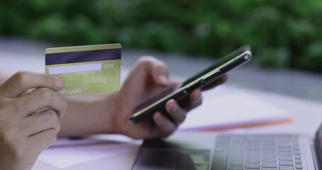 Poster - 4K Video close up hand hold credit card with digital device. Video concept for spending and e-commerce.