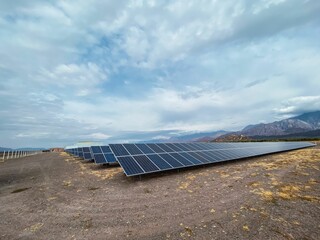 Wall Mural - Scenic view a wide land with solar panels arranged in row under the gloomy sky