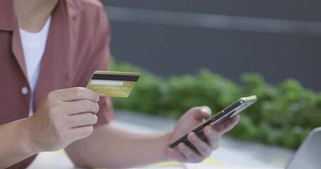 Poster - 4K Video close up hand hold credit card with digital device. Video concept for spending and e-commerce.
