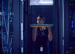 © Tetra Images - Female technician holding hard drive in server room
