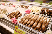 Chocolate Fondue With Fresh Banana. Fondue With Melted Chocolate And Banana. Banana Skewers With Melted Chocolate On Sticks At Fruit Stall For Sale At German Christmas Market Festival