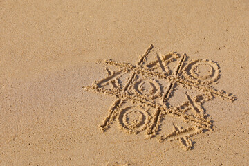 Canvas Print - Tic tac toe game drawn on sandy beach. Space for text