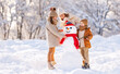 © JenkoAtaman - Happy family mother and two little kids making snowman together in winter park outdoors