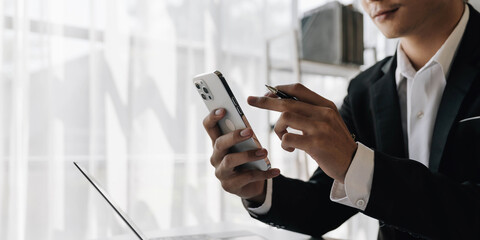 Asian businessman work in the office using tablet and mobile phone.