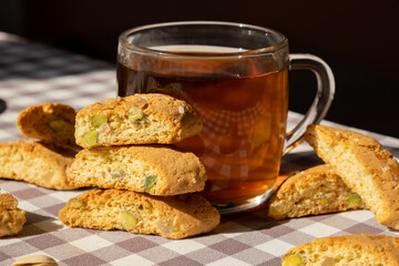 Biscotti Cantuccini Cookie Biscuits with pistachios and lemon peel Shortbread. Cup of tea. Teatime break Healthy eating food. Homemade fresh Italian cookies cantucci stacks and organic pistachios nuts