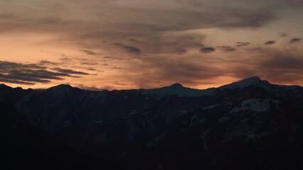 Wall Mural - View of clouds behind the snow covered Himalayan mountain peaks during the sunrise in winter season at Manali in Himachal Pradesh, India. Beautiful view of the clouds above the mountains in morning.